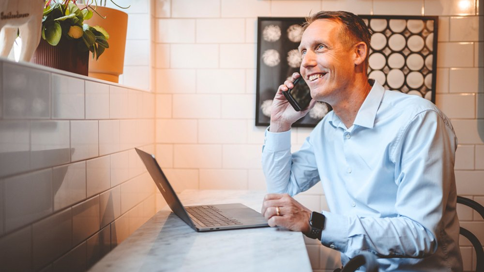 Person smiling and speaking on the phone